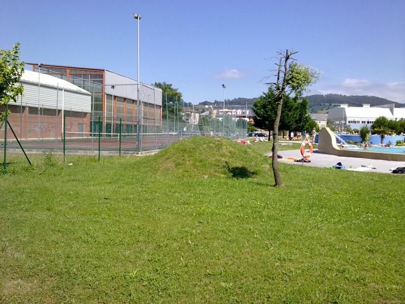 Zona deportiva con las piscinas, las pistas de tenis y el front?n al fondo