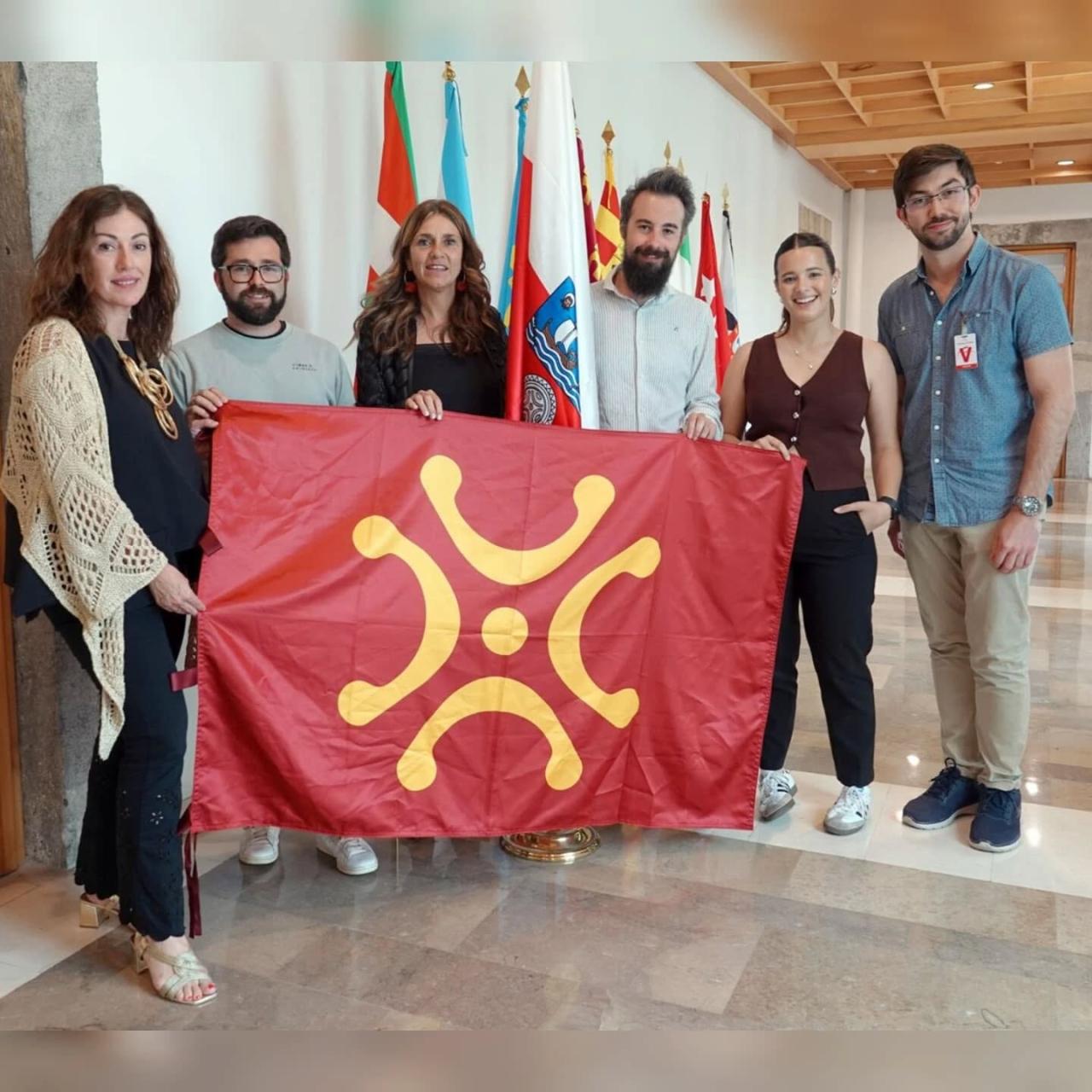 Jóvenes del PRC en el Parlamento de Cantabria con el lábaro y las diputadas Paula Fernández y Rosa Díaz
